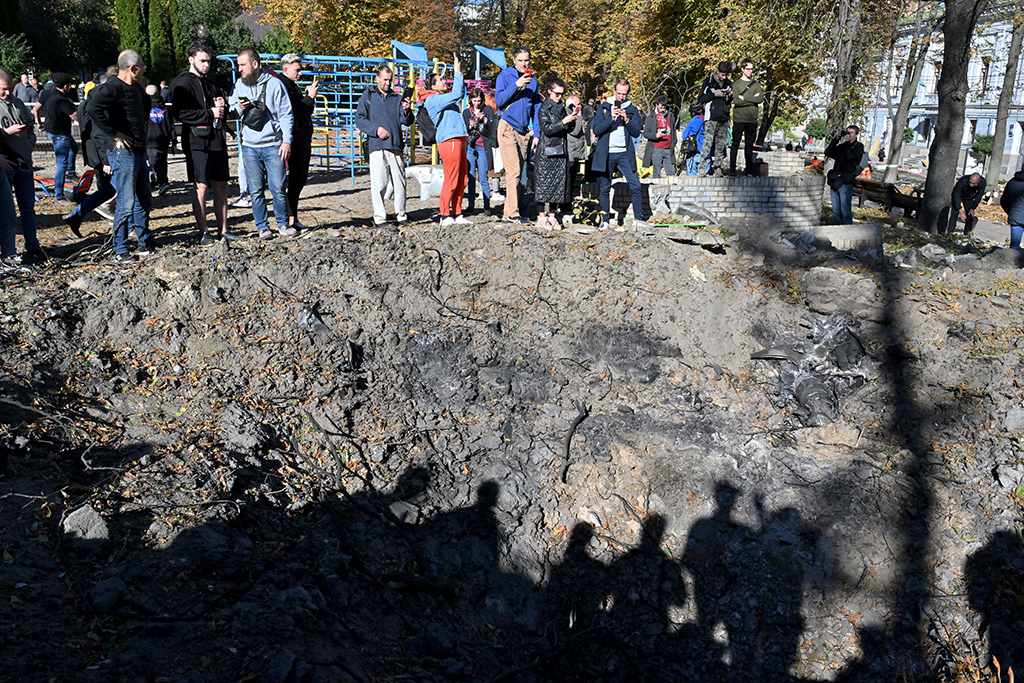 KYIV, Ukraine: People stand by a rocket crater next to a child playground in central Kyiv after Ukraine's capital was hit by multiple Russian strikes early on today. – AFP