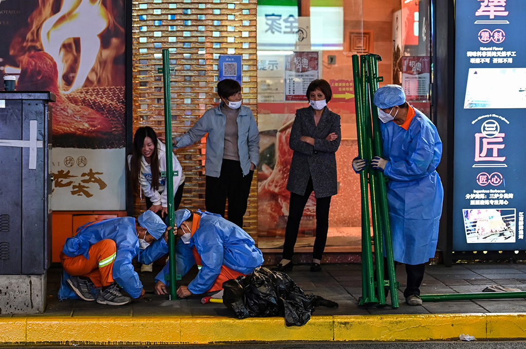 SHANGHAI, China: This photo taken late on October 7, 2022 shows workers erecting fencing around a neighbourhood in lockdown in Shanghai's Changning district, after new COVID-19 cases were reported. – AFP