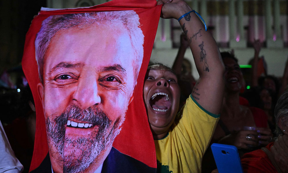 A supporter of Brazilian former President (2003-2010) and candidate for the leftist Workers Party (PT) Luiz Inacio Lula da Silva celebrates after her candidate won the presidential runoff election at the Cinelandia square in Rio de Janeiro, Brazil, on October 30, 2022.
