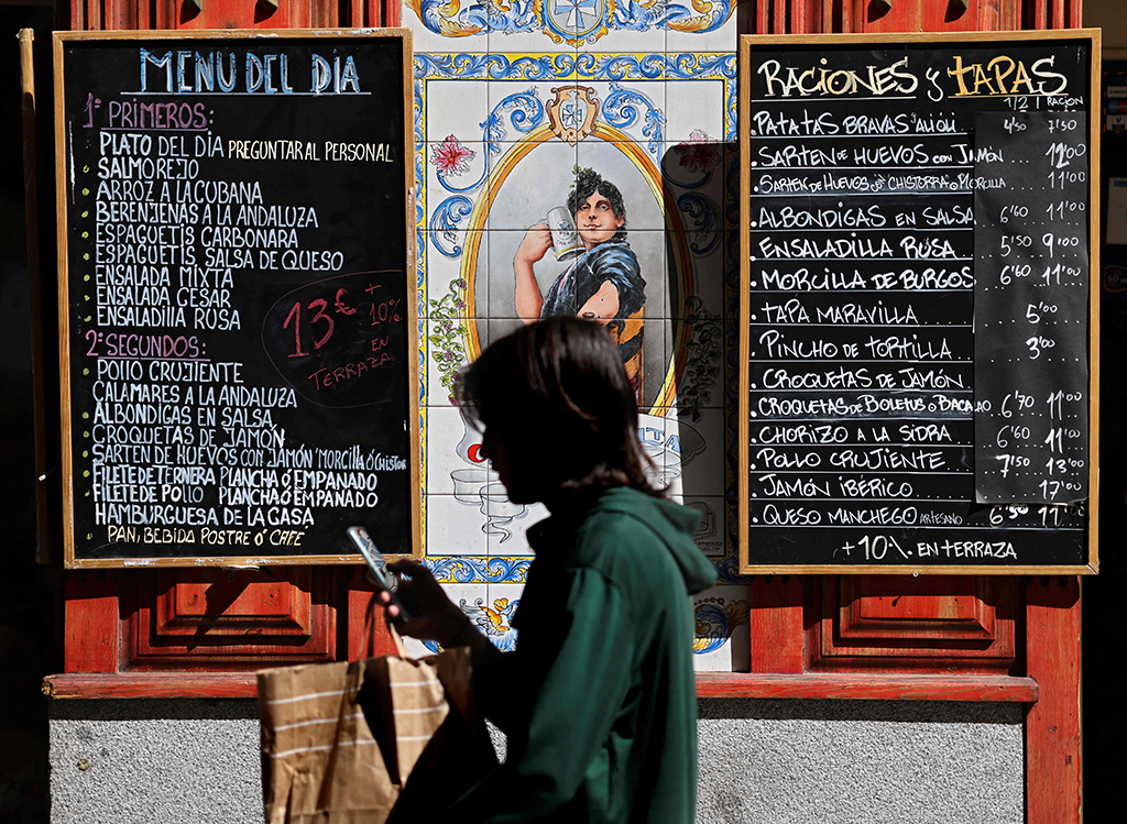 MADRID: A pedestrian walks past a board showing the day’s menu in the Spanish capital on Sept 5, 2022. – AFP