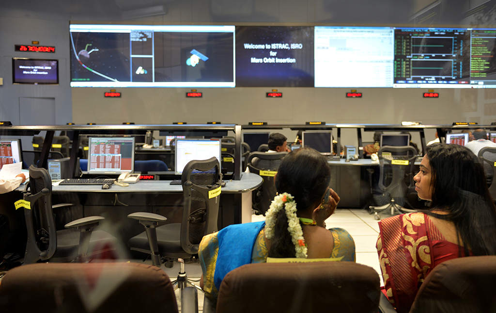 In this file photo, Indian staff from the Indian Space Research Organization (ISRO) watch as the Mars Orbiter Spacecraft (MoM) successfully enters the Mars orbit on a screen from a gallery at the ISRO Telemetry, Tracking and Command Network (ISTRAC). – AFP