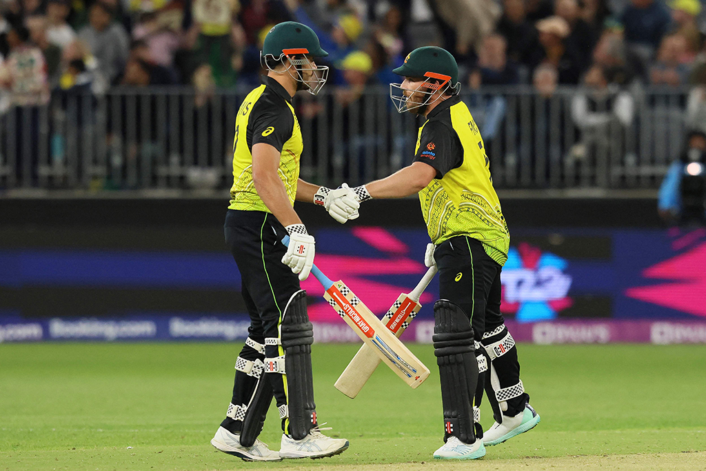 PERTH: Australia’s Aaron Finch (right) and Marcus Stoinis bump gloves during the ICC men’s Twenty20 World Cup 2022 cricket match between Australia and Sri Lanka at Perth Stadium on October 25, 2022.- AFP