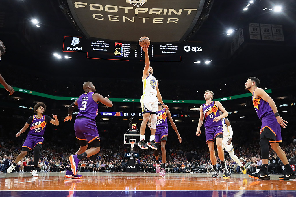 PHOENIX: Stephen Curry #30 of the Golden State Warriors lays up a shot against Chris Paul #3 of the Phoenix Suns during the second half of the NBA game at Footprint Center on October 25, 2022.- AFP