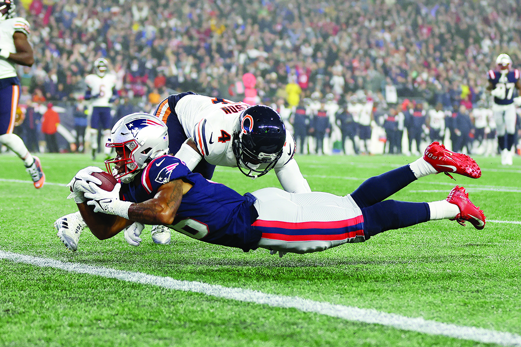 FOXBOROUGH: Jakobi Meyers #16 of the New England Patriots dives across the goal line to score a 30-yard receiving touchdown as Eddie Jackson #4 of the Chicago Bears is unable to make the tackle during the second quarter on October 24, 2022.- AFP