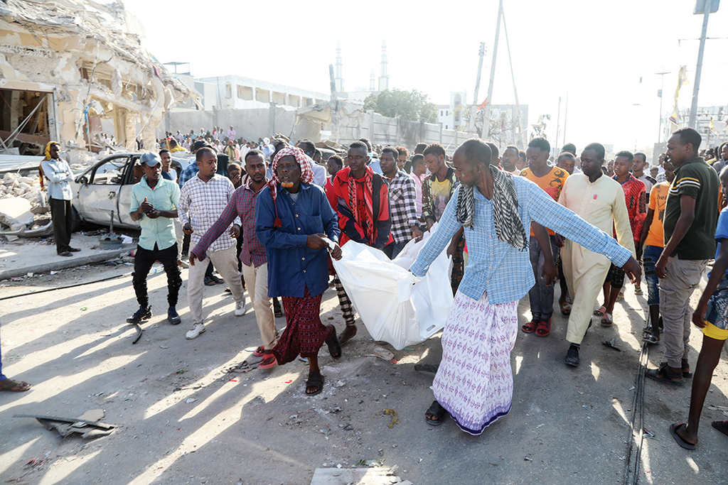 MOGADISHU: Residents carry the body of a victim on Oct 30, 2022 after twin car bombings targeted the education ministry on Oct 29, 2022. - AFP