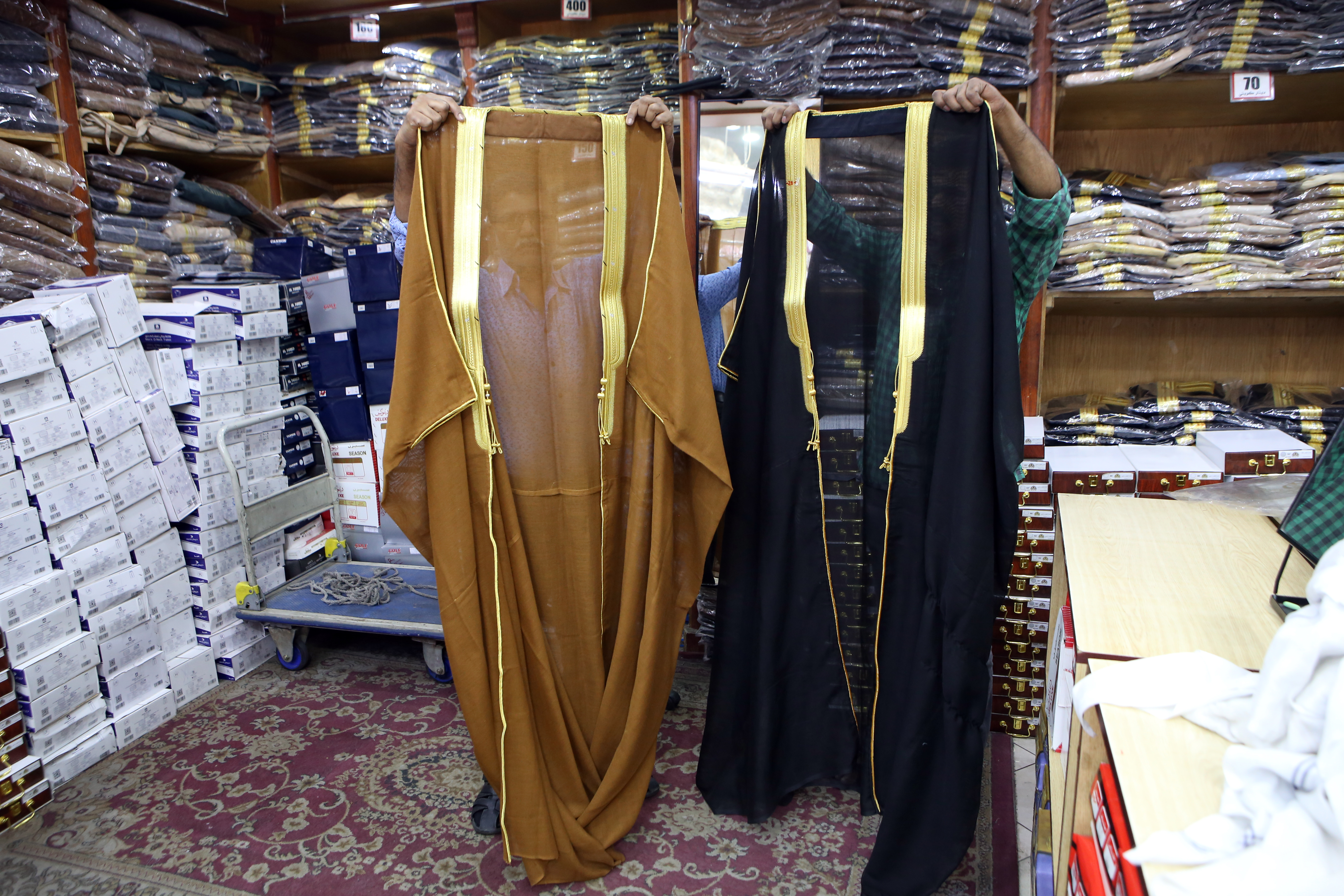 Salesmen show two traditional types of Bisht used in Kuwait.—photos by Yasser Al-Zayyat nnn