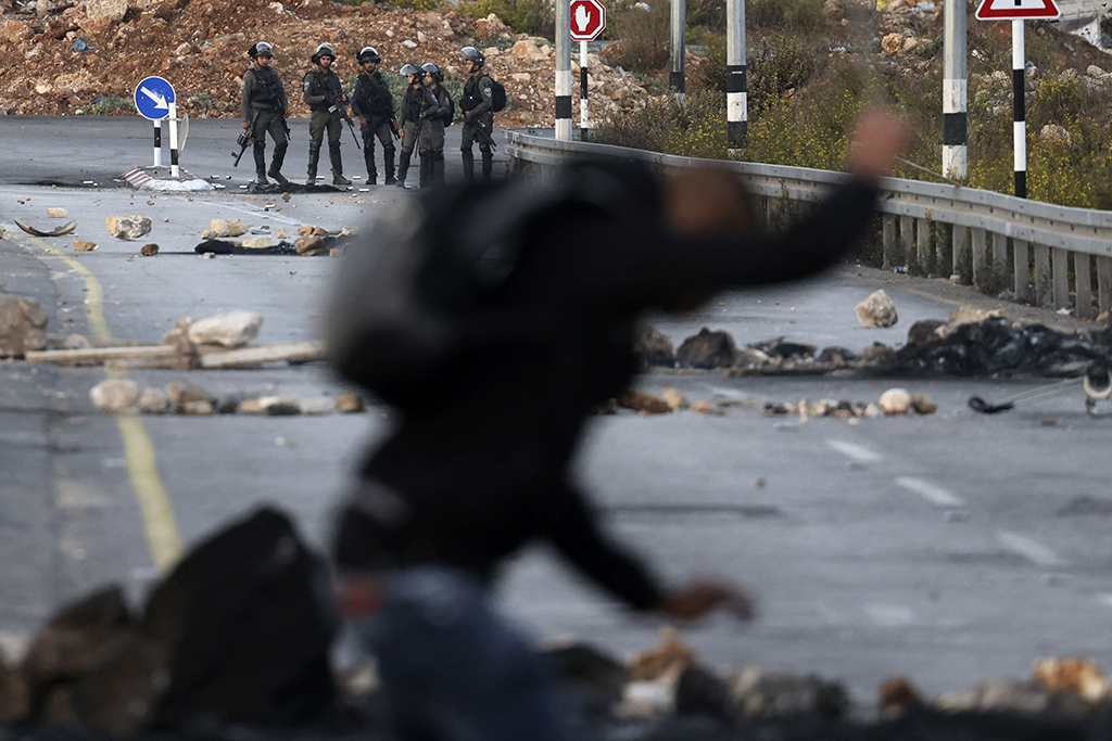 RAMALLAH: Zionist soldiers keep position during clashes with Palestinians at the northern entrance to the city of Ramallah, near the Israeli Beit El settlement in the occupied West Bank. - AFP
