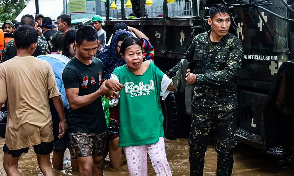 This handout photo taken by the Police Regional Office Bangsamoro Autonomous Region and released by the Philippine Coast Guard on October 28, 2022 shows rescue workers evacuating people from a flooded area due to heavy rain brought by Tropical Storm Nalgae in Parang, Maguindanao.