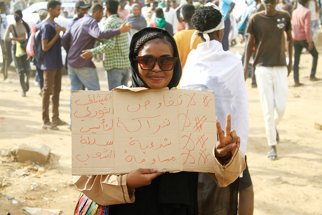 OMDOURMAN, Sudan: A Sudanese protester carries a placard during a march in Omdourman the capital Khartoum's twin city on October 21, 2022. Thousands of Sudanese took to the streets to renew protests nearly a year after a military coup led by General Abdel Fattah al-Burhan derailed the country's transition to democracy. - AFP