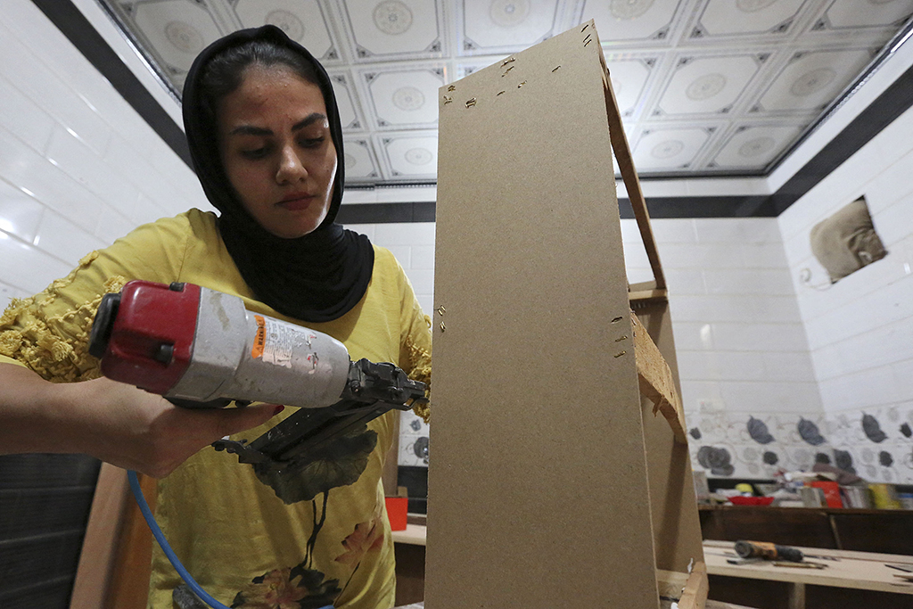 Iraqi carpenter Nour Al-Janabi works at her home furniture workshop in Baghdad's Abu Dsheer area.— AFP