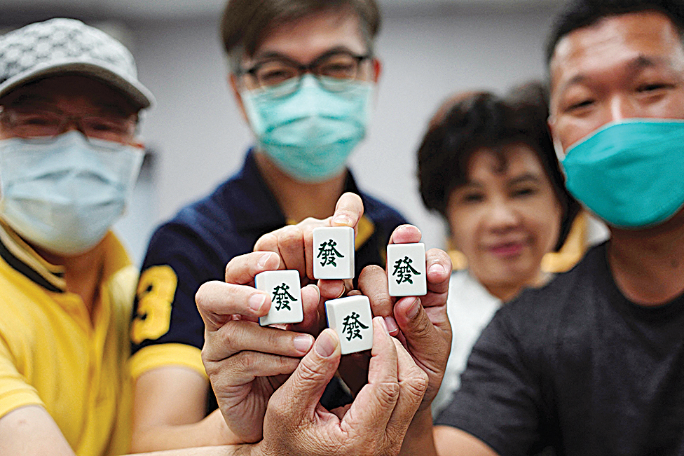  This picture shows mahjong enthusiasts posing with their game tiles at a parlor in Kaohsiung.— AFP photos