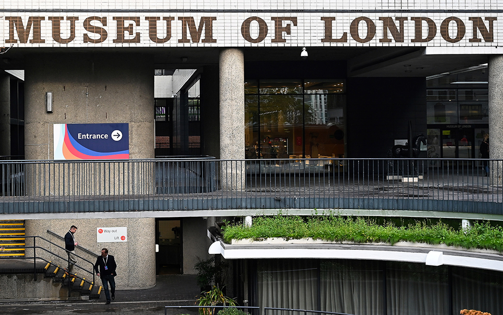 Two men walk past the entrance of the Museum of London.- AFP photos