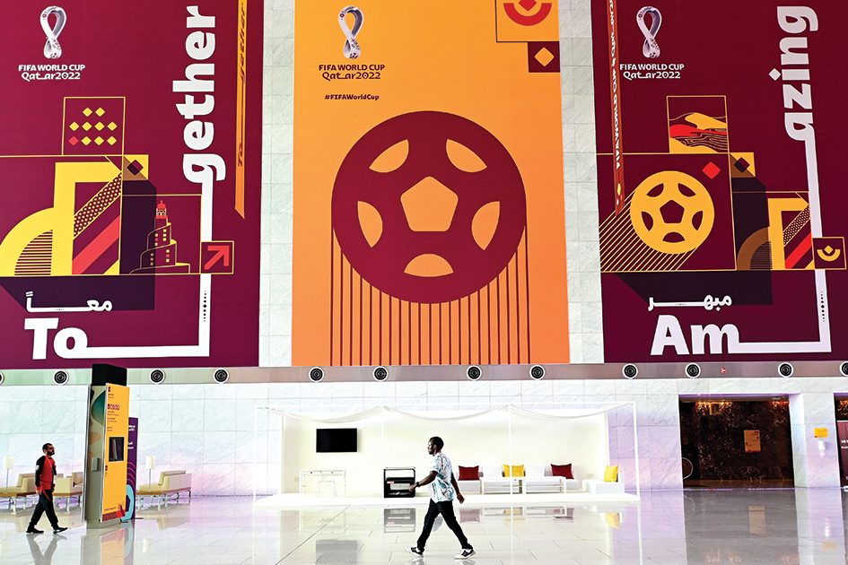 DOHA, Qatar: People walk past World Cup banners at the Qatar National Convention Center (QNCC) in Doha on November 13, 2022, ahead of the Qatar 2022 World Cup football tournament. – AFP