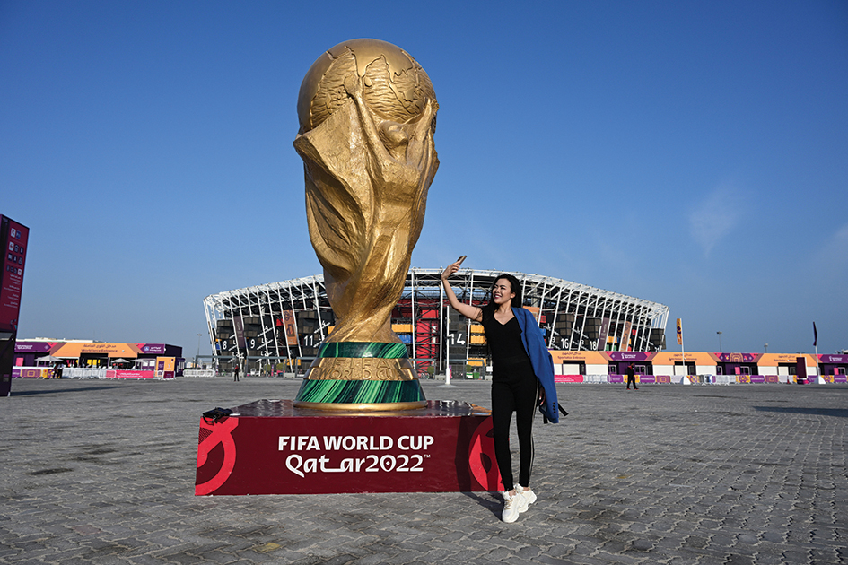 DOHA, Qatar: A woman takes a selfie with her mobile phone beside a giant replica of the FIFA World Cup trophy in front of the Stadium 974 in Doha on November 19, 2022, ahead of the Qatar 2022 World Cup football tournament. - AFP