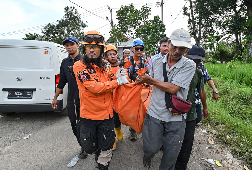 CIANJUR, Indonesia: Rescue workers carry the body of a victim in Cianjur on November 22, 2022, following a 5.6-magnitude earthquake that killed at least 268 people, with hundreds injured and others missing. – AFP