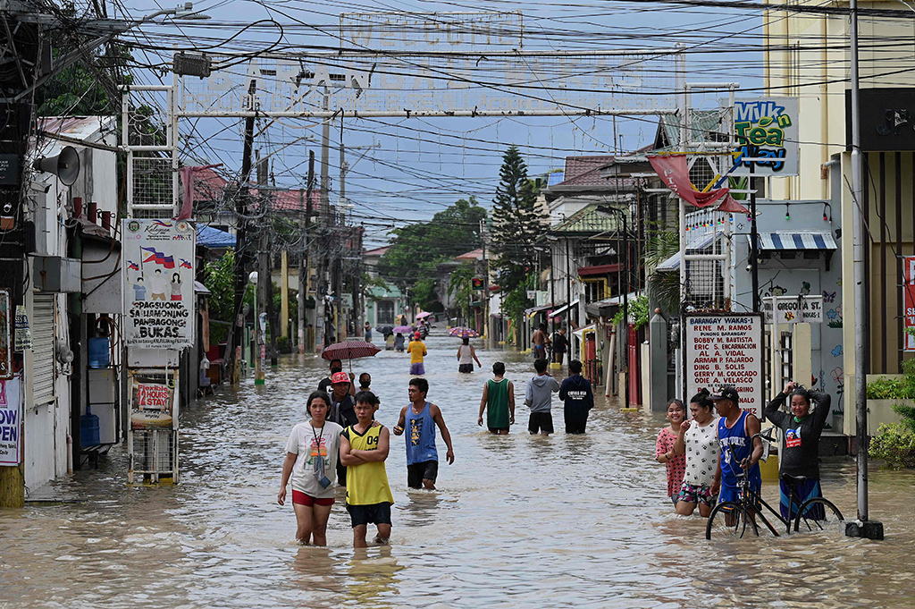 KAWIT, Philippines: People wade through a flooded street in Kawit, Cavite province after Tropical Storm Nalgae hit Philippines.  - AFP