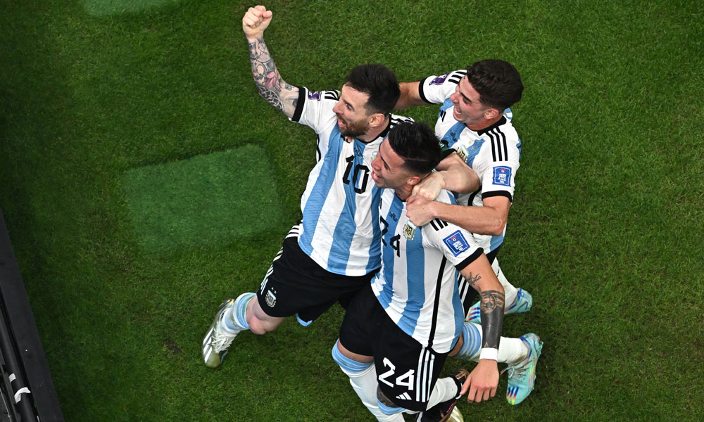 Argentina's midfielder #24 Enzo Fernandez (C) celebrates scoring his team's second goal with Argentina's forward #10 Lionel Messi (L) during the Qatar 2022 World Cup