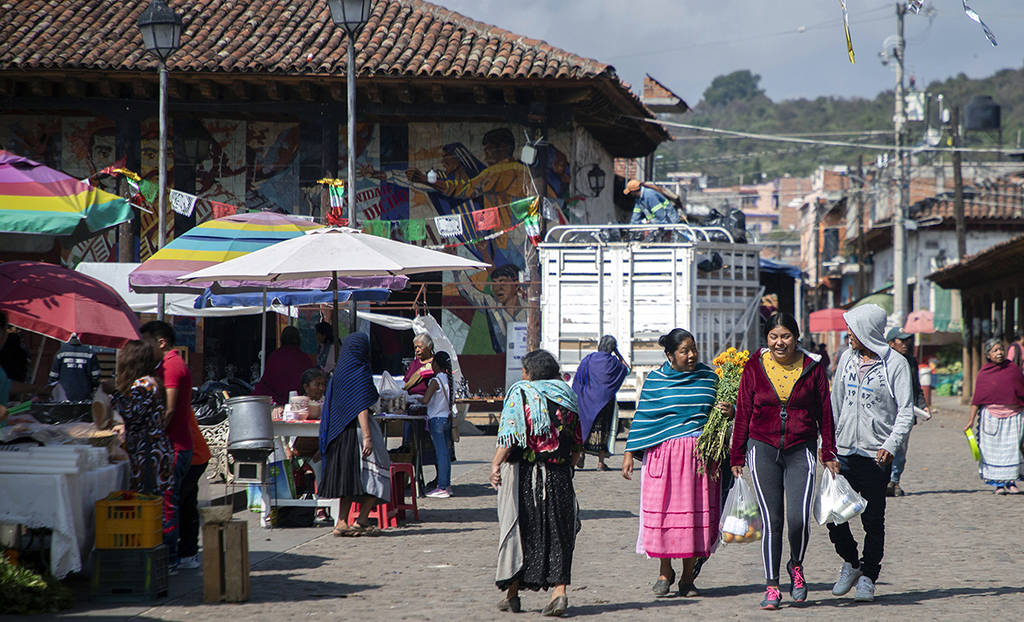 People walk in the town square where Maria Salud Ramirez Caballero, known as Mama Coco, lived in Santa Fe de la Laguna, Michoacan state, Mexico.- AFP photos