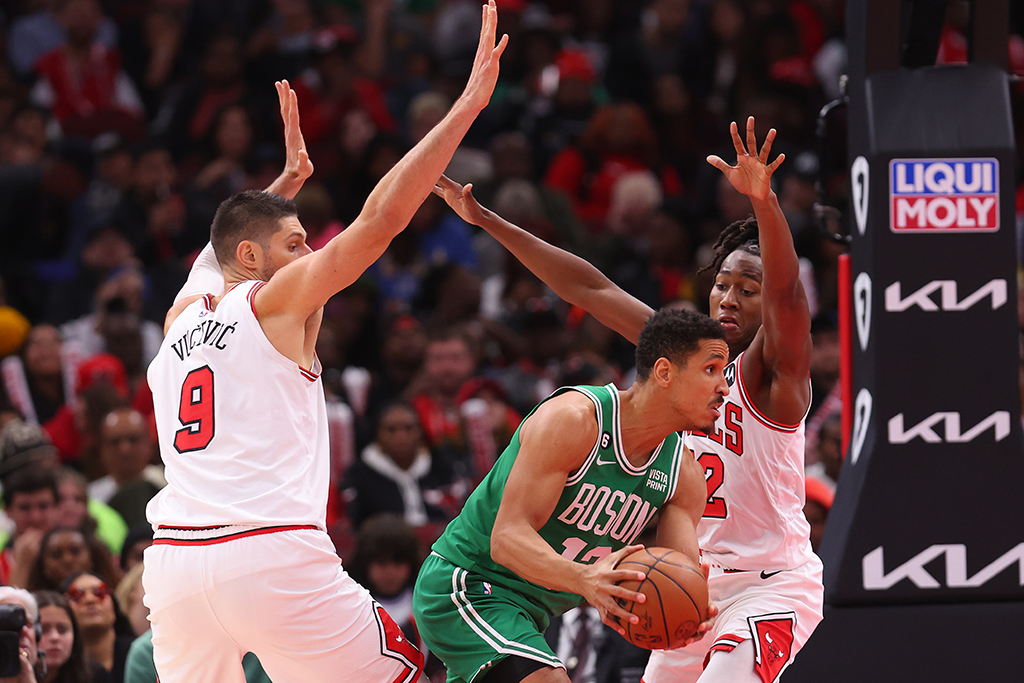 CHICAGO: Malcolm Brogdon #13 of the Boston Celtics passes the ball around Nikola Vucevic #9 and Ayo Dosunmu #12 of the Chicago Bulls during the second half at United Center on November 21, 2022. - AFP