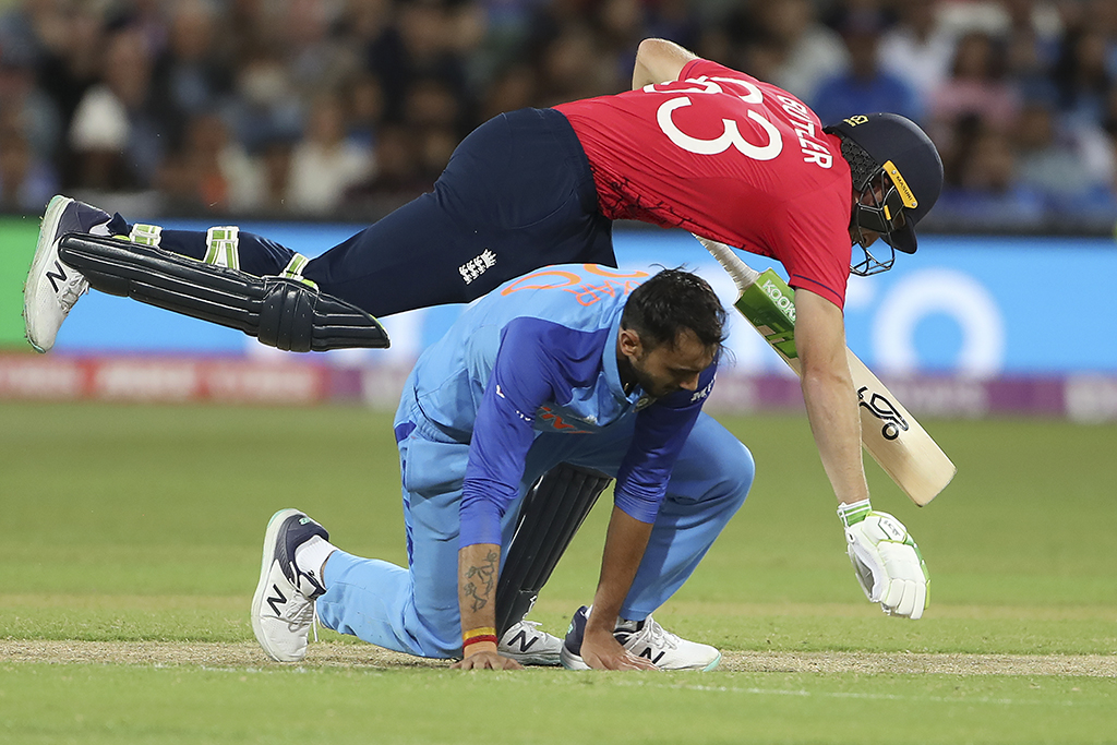 ADELAIDE: England's Captain Jos Buttler jumps over the India's Axar Patel as he runs between the wickets during the ICC men's Twenty20 World Cup 2022 semi-final cricket match between England and India on November 10, 2022.- AFP