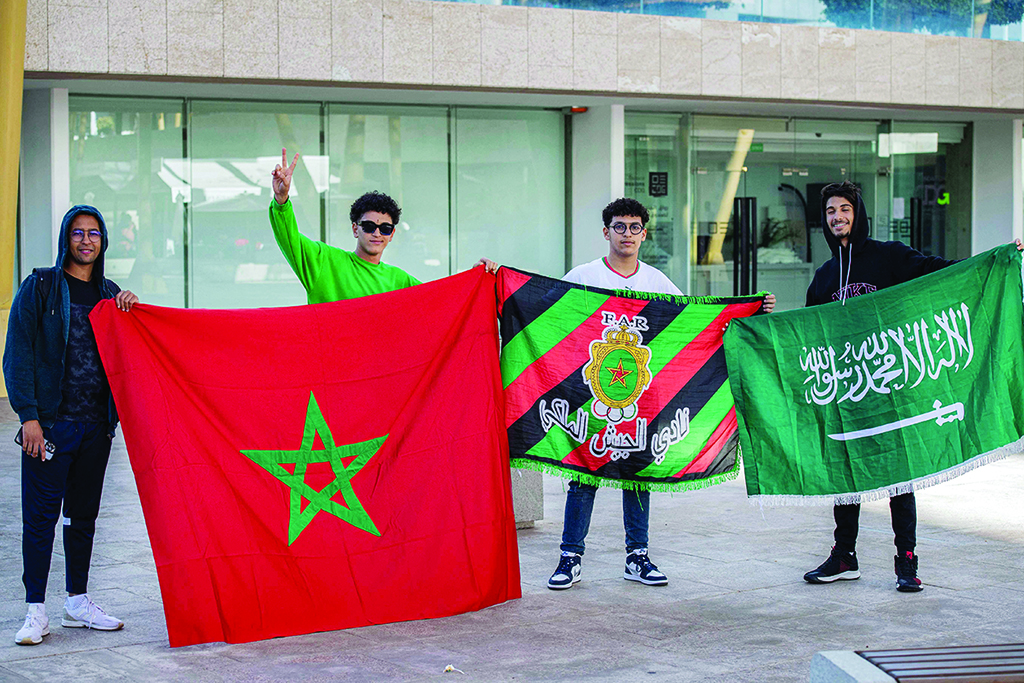 RABAT: Fans of the Morocco national team pose for a photo with their country's flag and that of Saudi Arabia after watching Morocco's Qatar 2022 FIFA World Cup match against Croatia at a cafe on Nov 23, 2022. - AFP