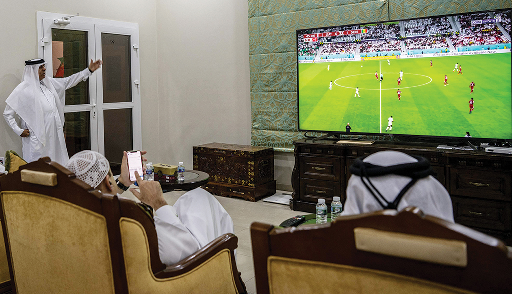 AL-JAMILIYA, Qatar: A group of men watch the Qatar 2022 World Cup football tournament match between Qatar and Senegal at Qatari businessman Youssef Al-Taher's home in his farm northwest of Doha on Nov 25, 2022. - AFP