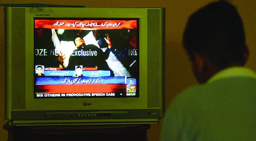ISLAMABAD: A boy watches a television channel showing the news of Pakistan's former prime minister Imran Khan on Nov 3, 2022. - AFP