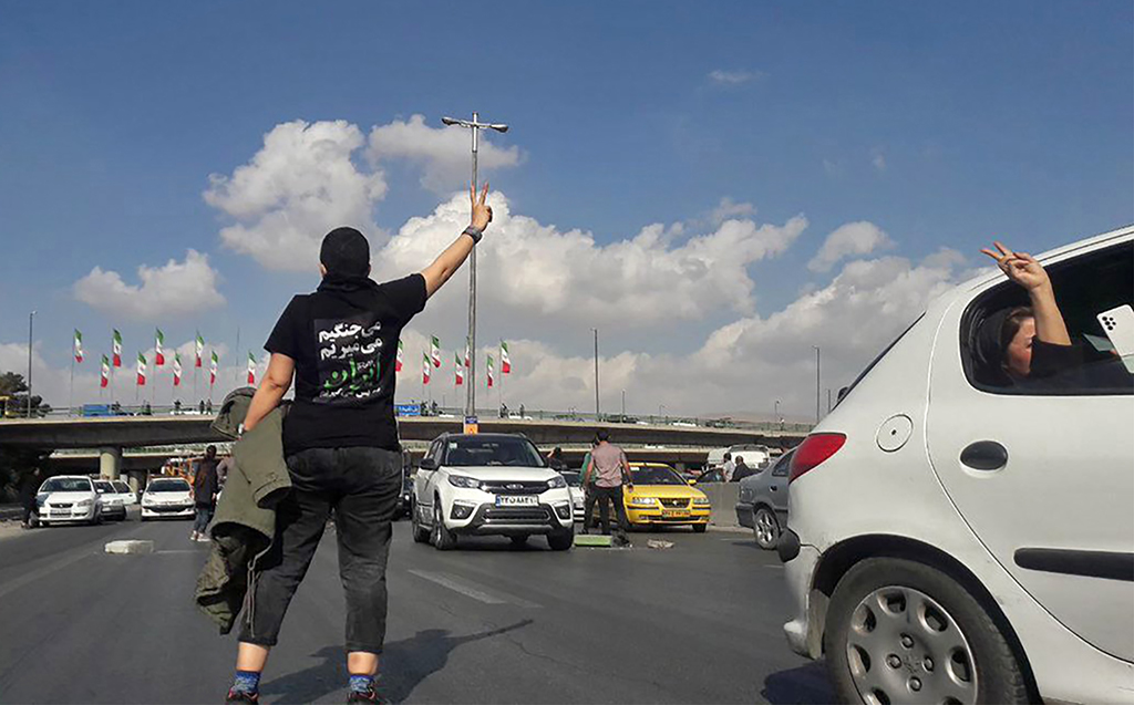 KARAJ, Iran: This UGC image posted on Twitter, shows a person, wearing a shirt which translates from Persian to “We will fight, we will die, we will take back Iran” , gesturing in the middle of a busy highway in the city of Karaj. – AFP