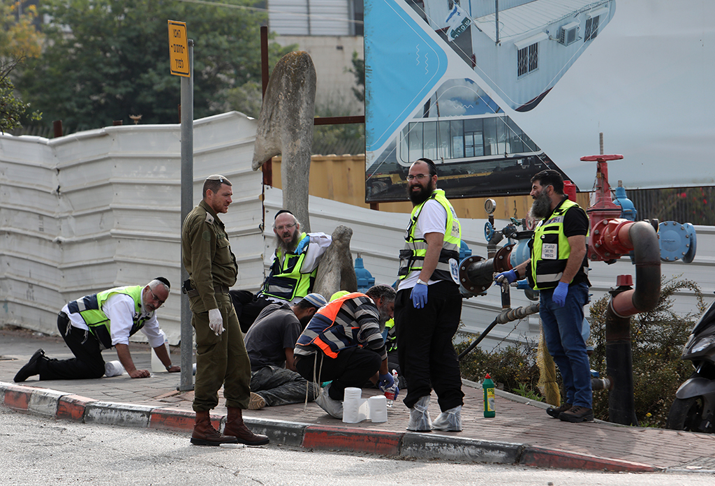 ARIEL, Palestinian Territories:  Israeli Zaka volunteers, an ultra-Orthodox Jewish emergency response team, work at the scene of an attack in the Ariel Industrial Zone in the occupied West Bank on November 15, 2022, in which a Palestinian killed two Zionists. – AFP