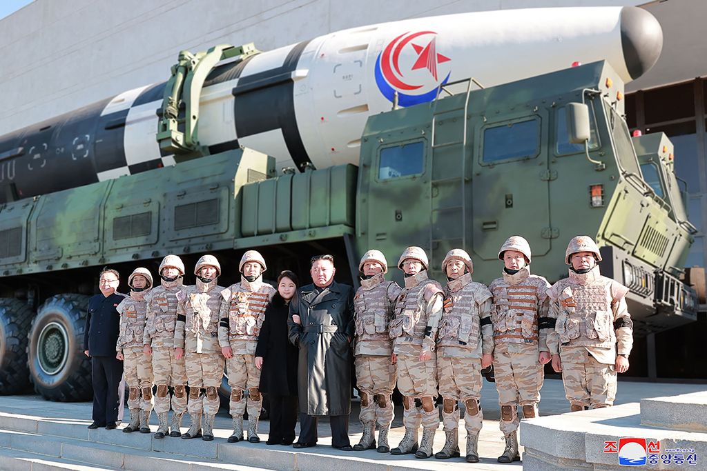 This undated picture released from North Korea’s official Korean Central News Agency (KCNA) on November 27, 2022 shows North Korea’s leader Kim Jong Un (centre right) and his daughter (centre left) posing with soldiers who contributed to the test-firing of the new intercontinental ballistic missile (ICBM), at an unknown location in North Korea. – AFP