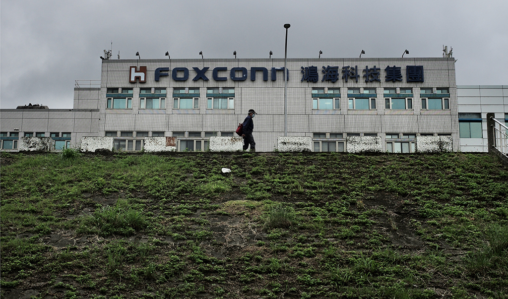 NEW TAIPEI CITY, Taiwan:  This file photo shows a man walking past the Foxconn headquarters in Tucheng district, New Taipei City. – AFP