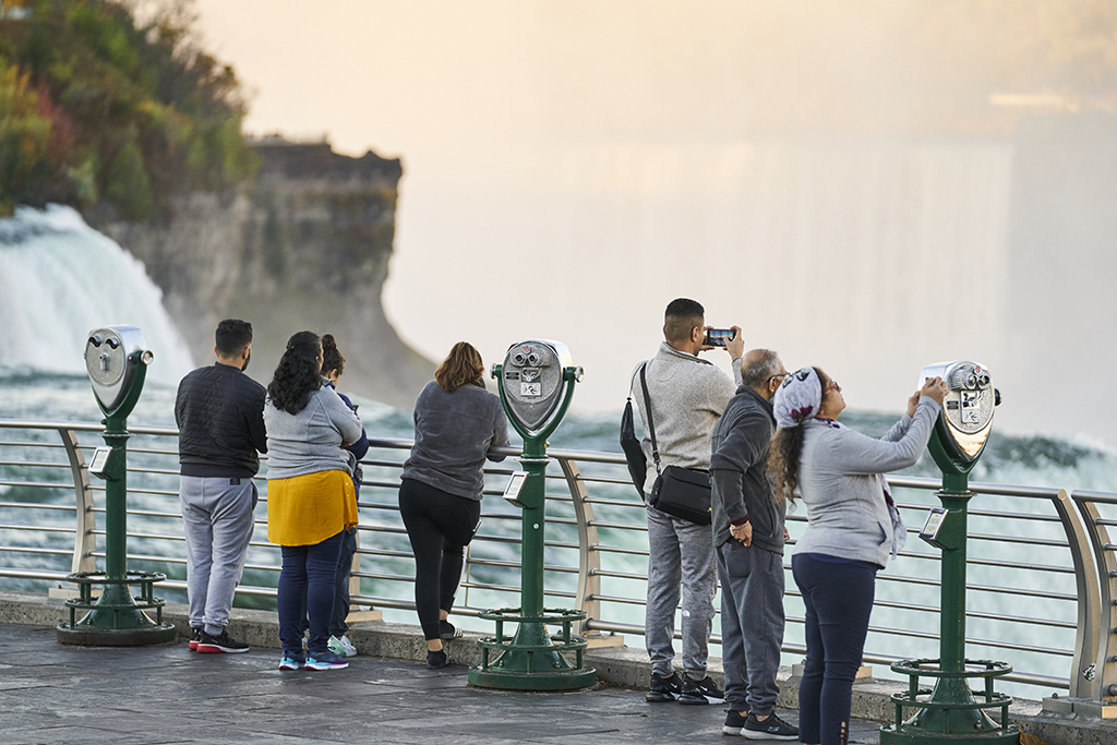 NIAGARA FALLS, US: Tourists take photos at the American Falls in Niagara Falls, New York on October 25, 2022. In the US city of Niagara Falls, residents accustomed to the soothing rumble of famous waterfalls have recently discovered a much less pleasant sound: the roar of bitcoin mining farms. – AFP