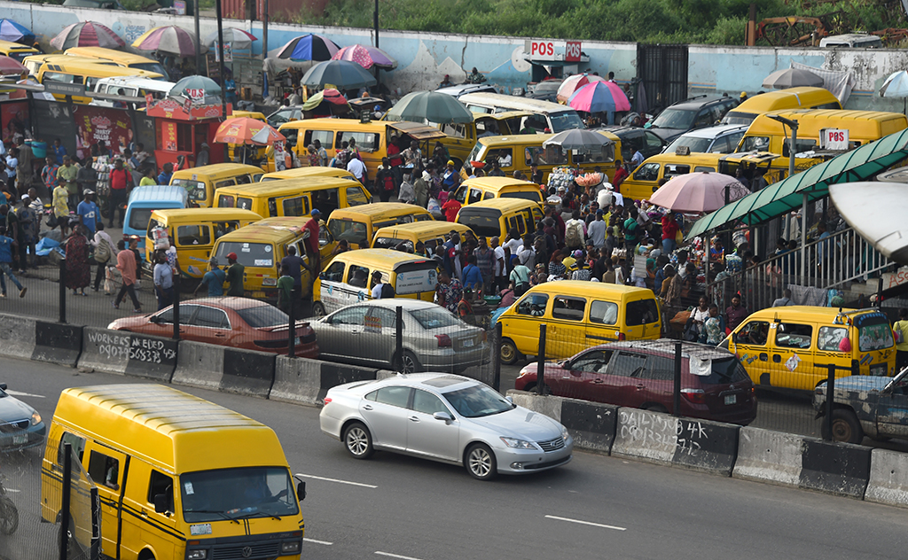 LAGOS, Nigeria: Commuters board yellow painted mini buses, popularly called Danfo, parked at the Ojodu-Berger bus station in Lagos, Nigeria's commercial capital. – AFP