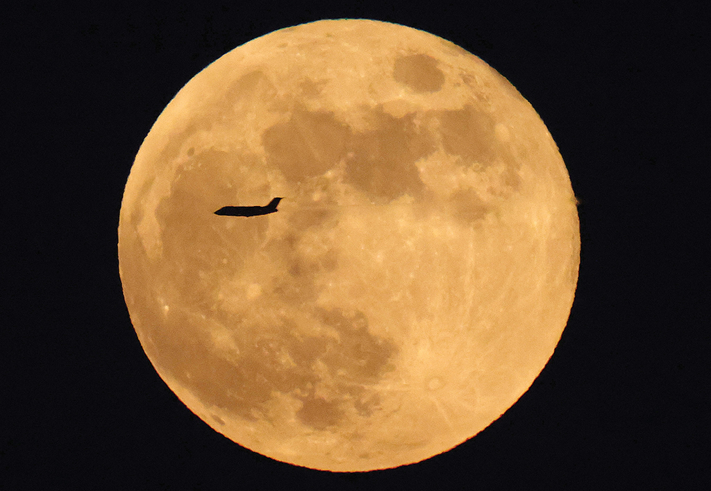 KUWAIT: A commercial aircraft is framed by the rising full moon above Kuwait City on Nov 8, 2022. —  Photo by Yasser Al-Zayyat