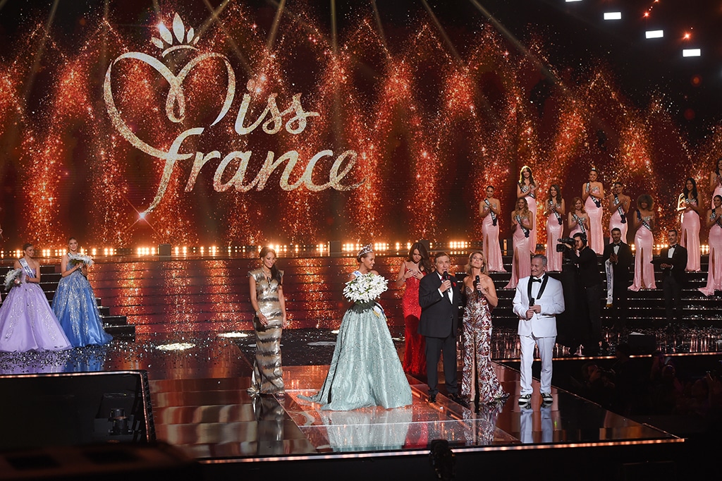 Newly elected miss France Indira Ampiot (center) reacts TV host Jean-Pierre Foucault (2th R) speak during the Miss France 2023 beauty contest. 