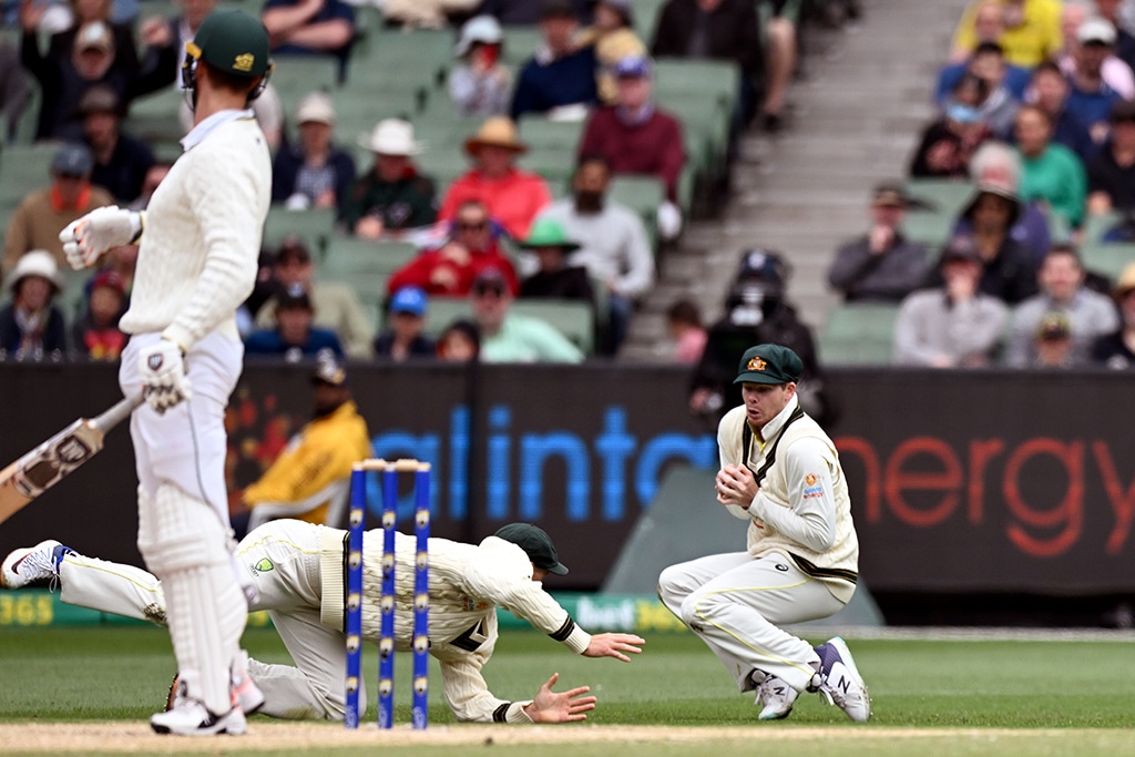MELBOURNE: Australia's Steve Smith takes a catch to dismiss South African batsman Theunis de Bruyn (L) on the fourth day of the second cricket Test match between Australia and South Africa at the MCG in Melbourne on December 29, 2022. - AFP