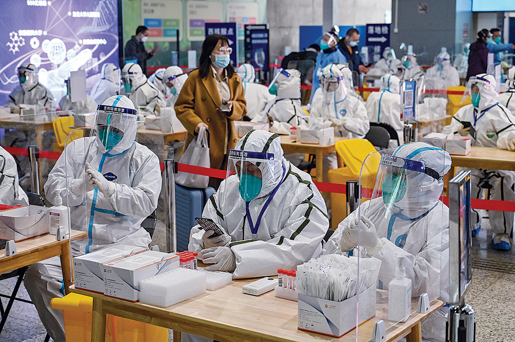 SHANGHAI, China: Health workers wait to test passengers for the COVID-19 coronavirus after their arrival at Hongqiao railway station in Shanghai. - AFP