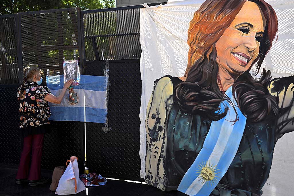 BUENOS AIRES, Argentina: A supporter of Argentina's Vice-President Cristina Fernandez de Kirchner sticks a sign outside the Courthouse Comodoro Py in Buenos Aires. – AFP