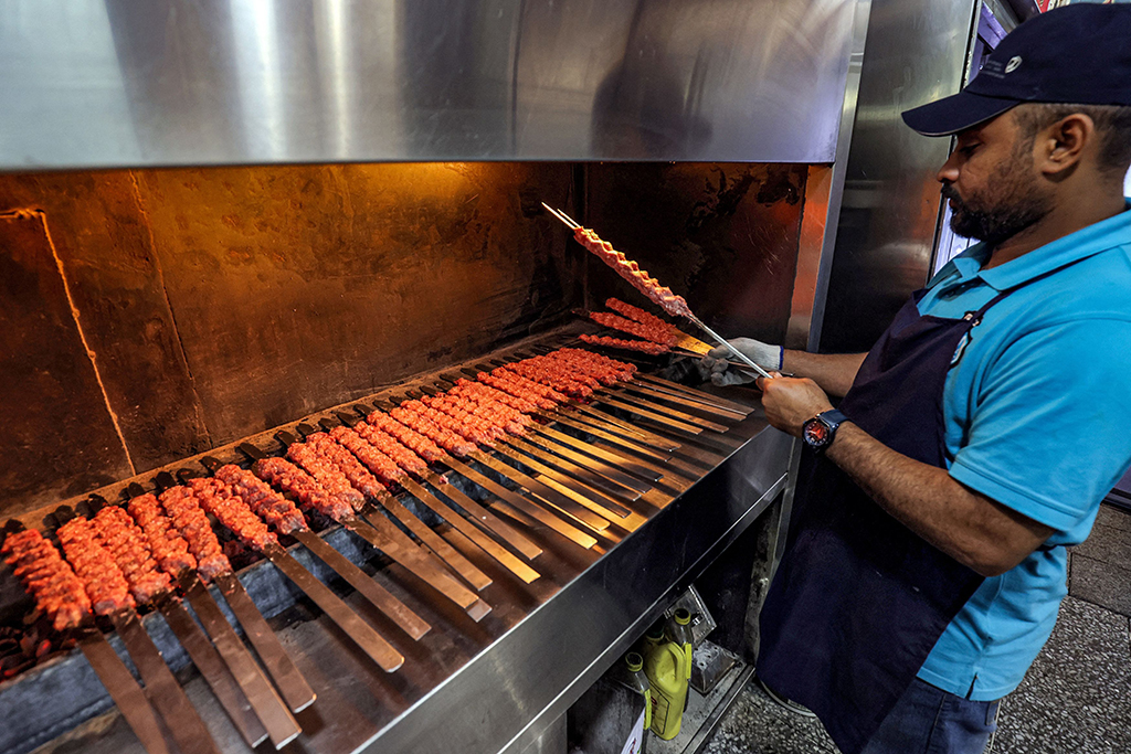 KUWAIT: A restaurant worker prepares grilled meat skewers at a restaurant in Souq Mubarakiya in Kuwait City. — Photo by Yasser Al-Zayyat