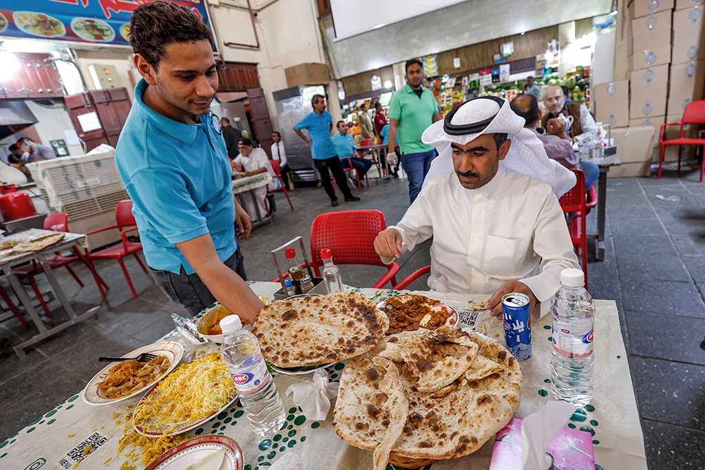 KUWAIT: A waiter serves a meal to a customer at a restaurant at Mubarakiya market in the centre of Kuwait City. - Photo by Yasser Al-Zayyat