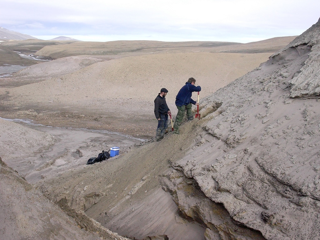 This undated handout photo received on December 6, 2022 shows Eske Willerslev and Kurt H Kjær exposing fresh layers for sampling of sediments at the Kap Kobenhavn geological formation in northern Greenland, Denmark.