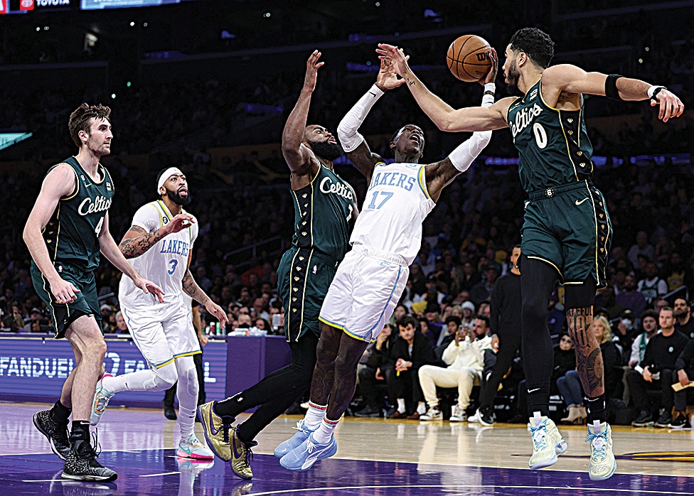 LOS ANGELES: Dennis Schroder #17 of the Los Angeles Lakers reacts as he is fouled between Jaylen Brown #7 and Jayson Tatum #0 of the Boston Celtics during a 122-118 loss to the Celtics at Crypto.com Arena on December 13, 2022.- AFP