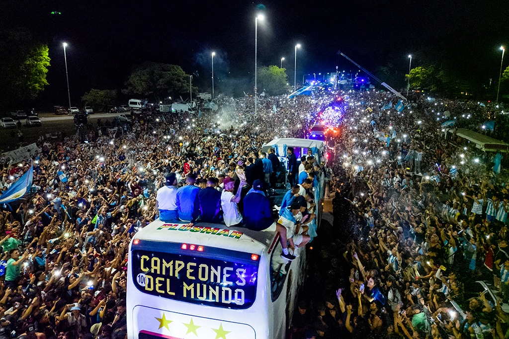 BUENOS AIRES: Argentina's players celebrate on board a bus with a sign reading 'World Champions' with supporters after winning the Qatar 2022 World Cup tournament as they leave Ezeiza International Airport en route to the Argentine Football Association (AFA) training centre in Ezeiza, Buenos Aires province on December 20, 2022. - AFP