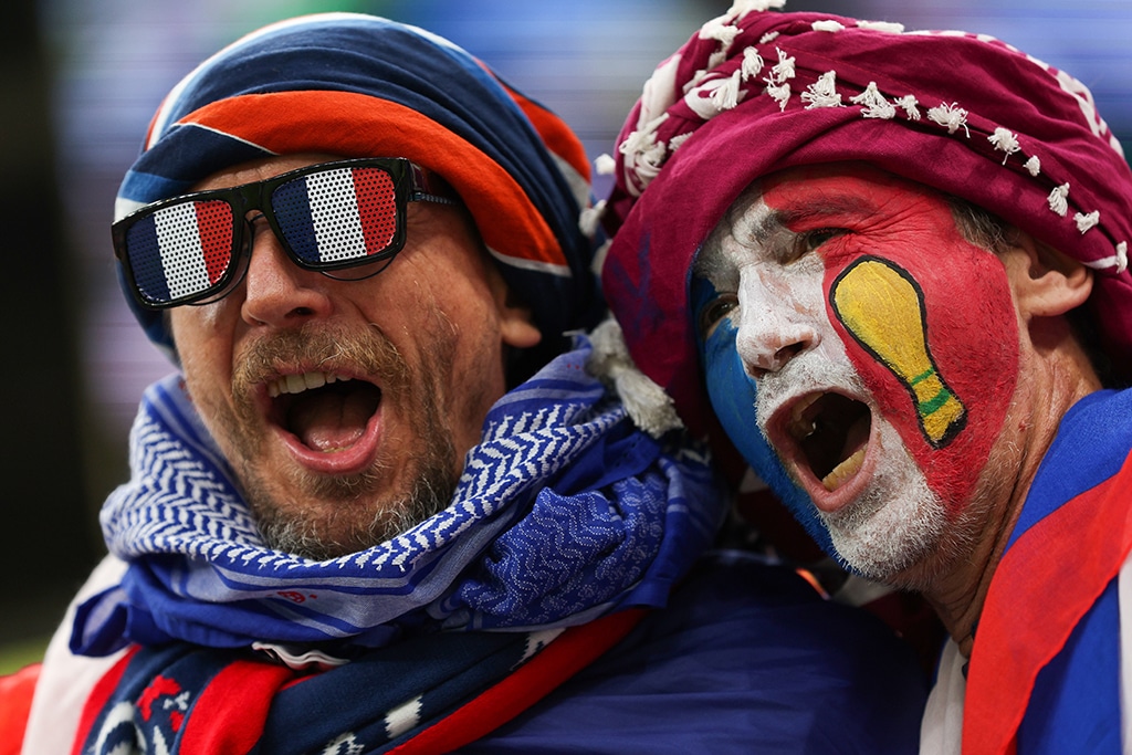LUSAIL: A France supporter (right) with the France national flag and the FIFA World Cup Trophy painted on his face cheers during the Qatar 2022 World Cup final football match between Argentina and France at Lusail Stadium in Lusail.- AFP