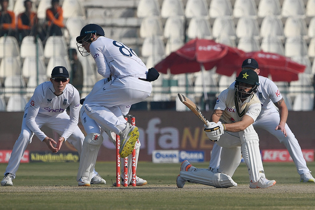 MULTAN: Pakistan's Mohammad Nawaz (2nd right) plays a shot as England's Harry Brook (2nd left) jumps during the fourth day of the second cricket Test match between Pakistan and England at the Multan Cricket Stadium in Multan on December 12, 2022. - AFP