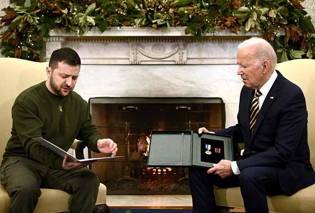 WASHINGTON: Ukraine's President Volodymyr Zelensky presents a Ukrainian military medal to US President Joe Biden in the Oval Office of the White House on Dec 21, 2022. - AFP