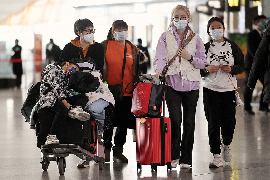BEIJING: Passengers walk through a departure terminal of the international airport on Dec 29, 2022. - AFP