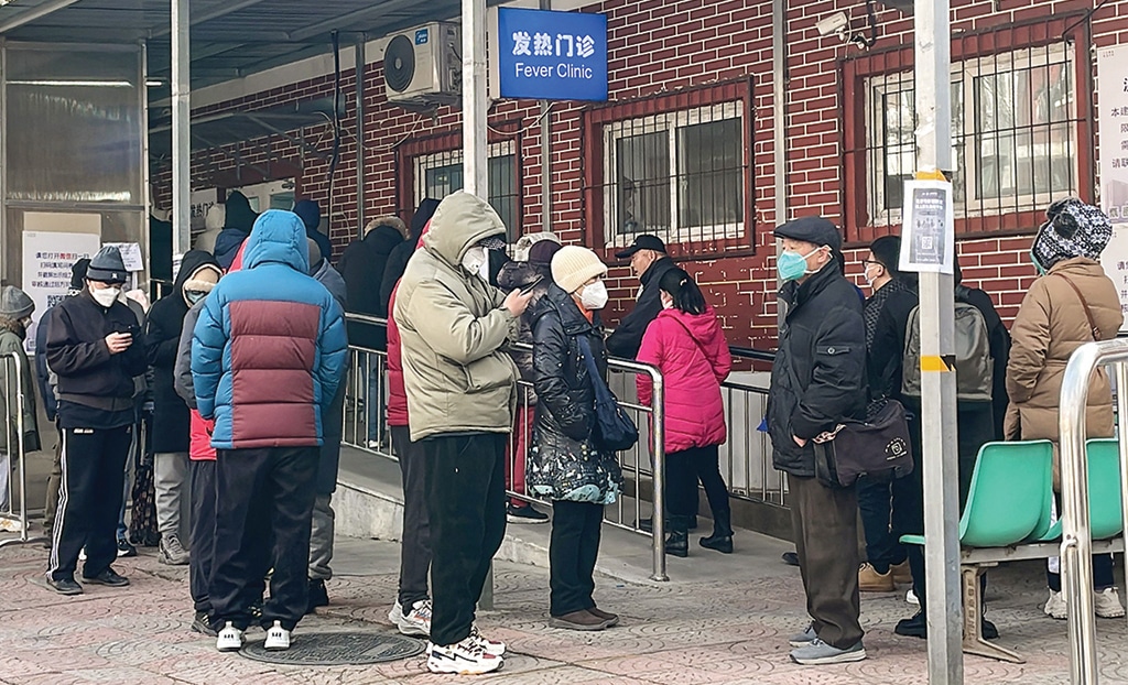 BEIJING: People queue outside a fever clinic amid the COVID-19 pandemic on Dec 14, 2022. - AFP