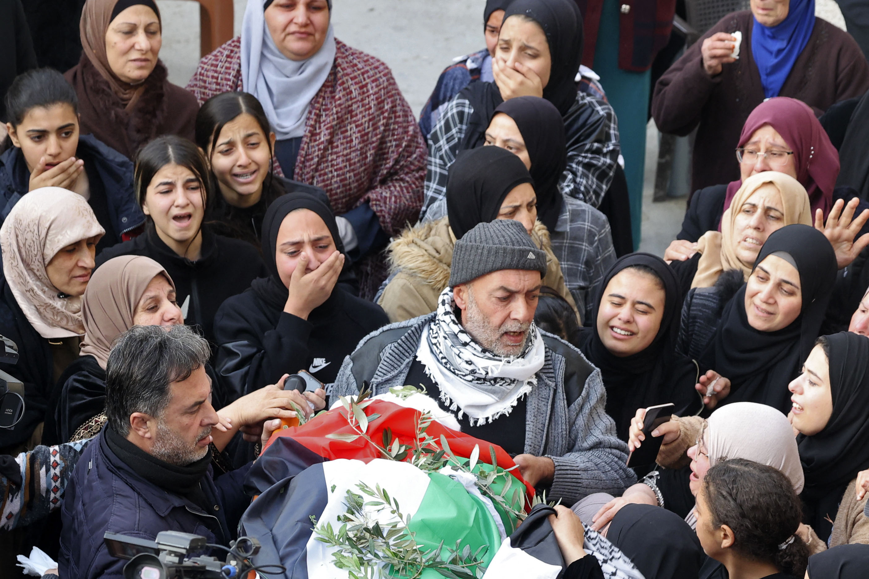 Palestinian mourners attend the funeral of 16-year-old Jana Zakarnaa, who was killed during an Israeli raid in the occupied West Bank, on December 12, 2022 in the city of Jenin. - The teenage Palestinian girl was found shot dead on the roof of her house after an Israeli raid in the occupied West bank, official Palestinian sources said. (Photo by JAAFAR ASHTIYEH / AFP)
