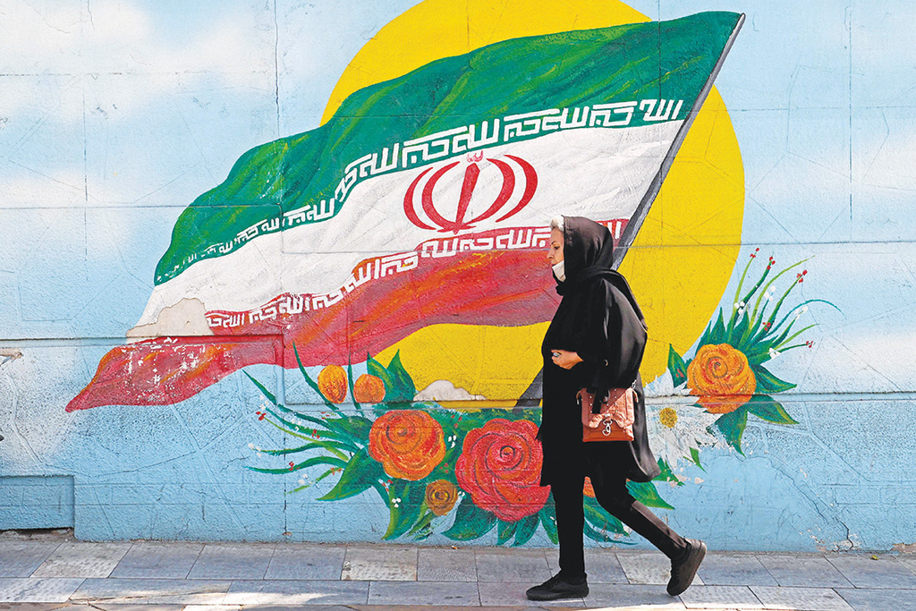 TEHRAN: In this photo taken on Oct 11, 2022, a woman walks past a mural in the Iranian capital. - AFP